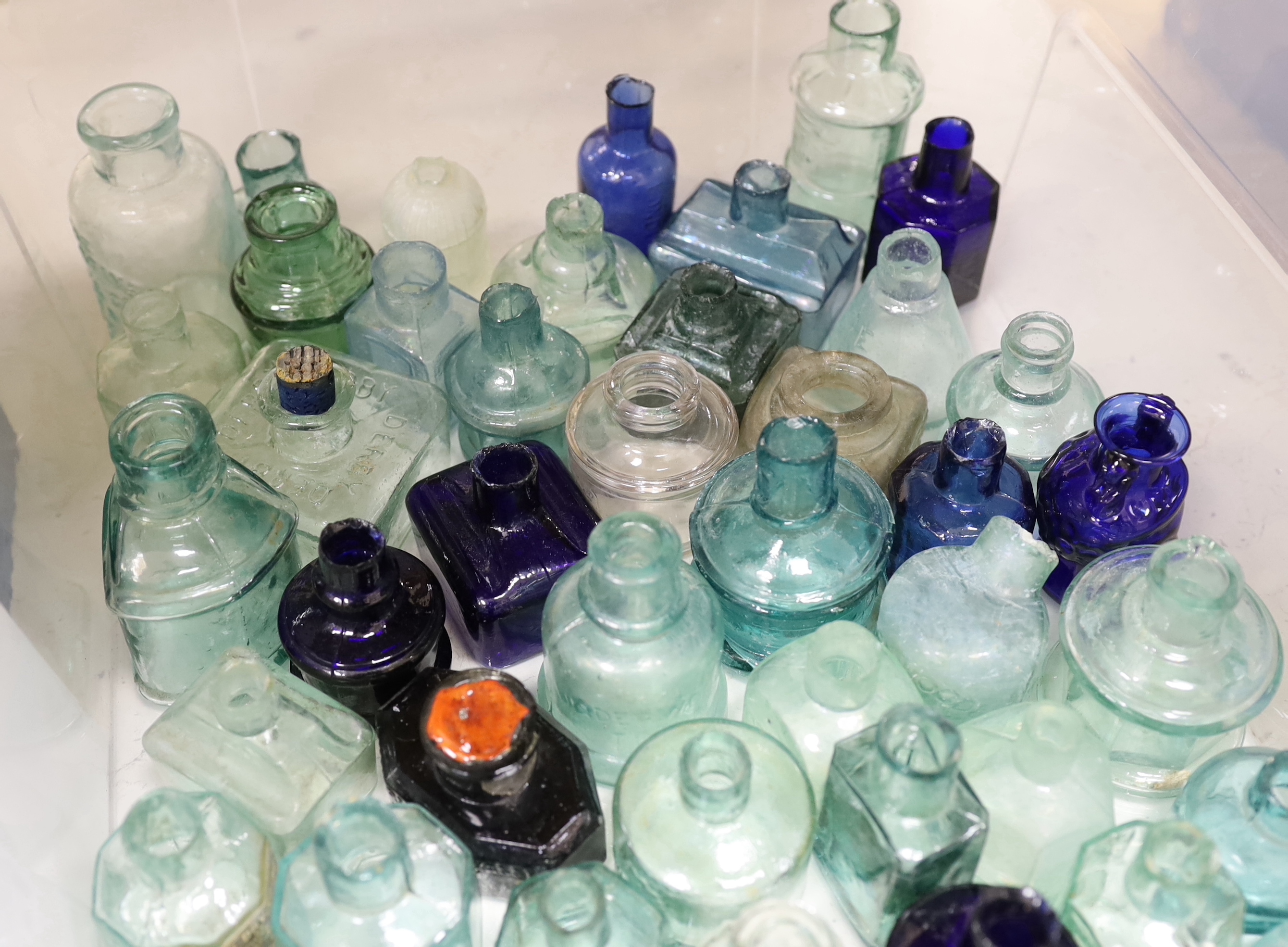 A collection of late 19th/early 20th century glass ink bottles, medicine bottles, sauce bottles and other glass vessels, brand names and advertising moulded into the glass on some examples, original paper labels to two i
